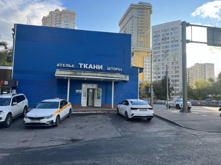 Главный вход в салон: синий фасад с вывеской «Ателье · Ткани · Шторы»